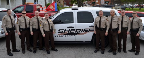 Eight deputies of the Patrol Division standing in front of one of their patrol vehicles.